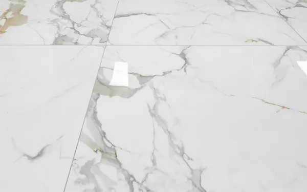Large-format marble-look floor tiles with tight grout lines