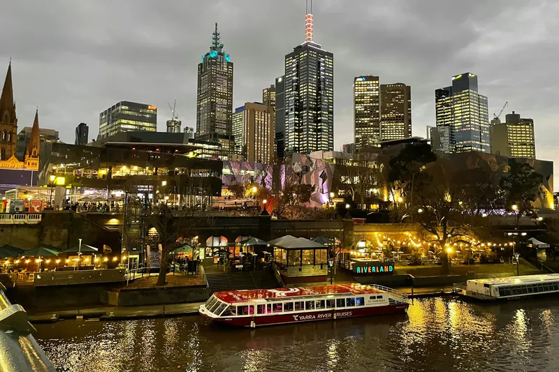 Melbourne’s city skyline lit up at dusk above the Yarra River