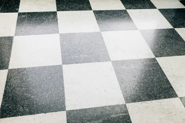 Black and white checkerboard floor tiles with fine grout lines