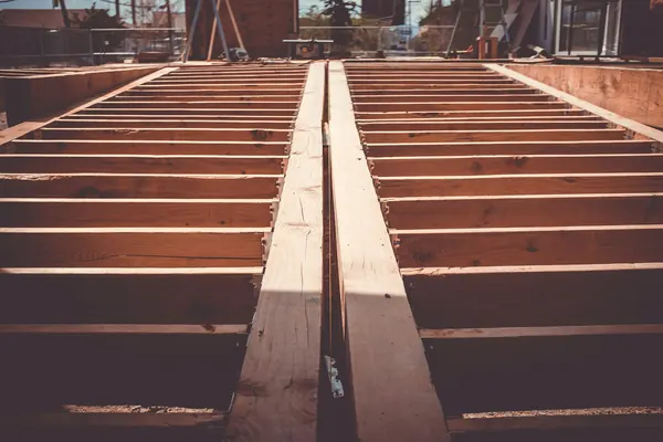 Timber floor joists set out across a new building site