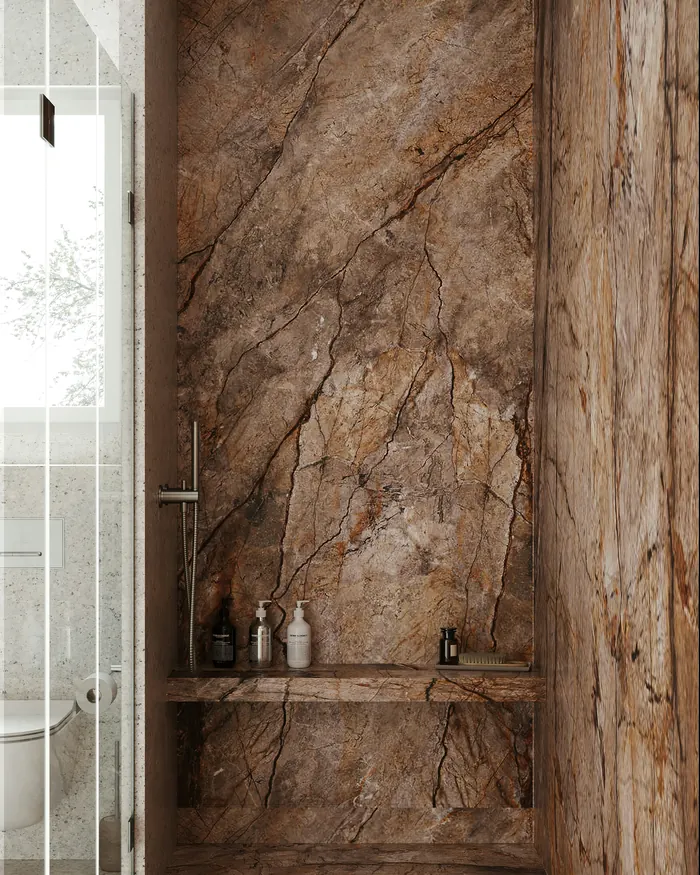 Walk-in shower lined in brown marble, with a recessed niche and a stone shelf