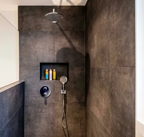 Walk-in shower in large charcoal tiles with a recessed niche