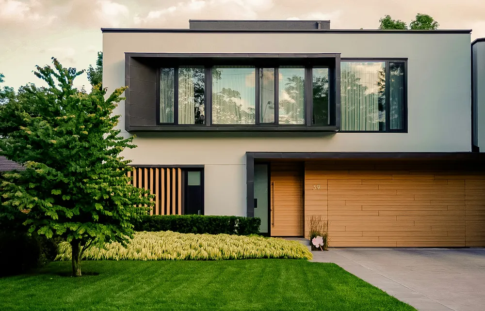 Contemporary two-storey home with a rendered facade, black window frames and a timber garage door